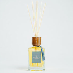Fragranza Muse Tuberose. Diffusore a bastoncini Euthalia Fragrances, con flacone in vetro trasparente. Il tappo in legno e i bastoncini completano il design elegante, ideale per profumare ambienti con una fragranza raffinata e di lunga durata.