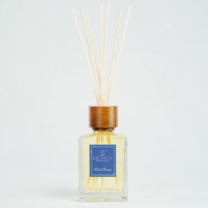 Fragranza Herbes Sauvages. Diffusore a bastoncini Euthalia Fragrances, con flacone in vetro trasparente. Il tappo in legno e i bastoncini completano il design elegante, ideale per profumare ambienti con una fragranza raffinata e di lunga durata.