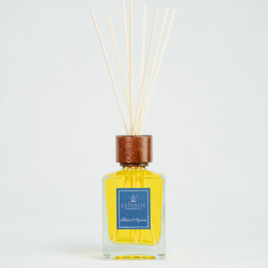 Fragranza Plaisir d'Agrumes. Diffusore a bastoncini Euthalia Fragrances, con flacone in vetro trasparente. Il tappo in legno e i bastoncini completano il design elegante, ideale per profumare ambienti con una fragranza raffinata e di lunga durata.
