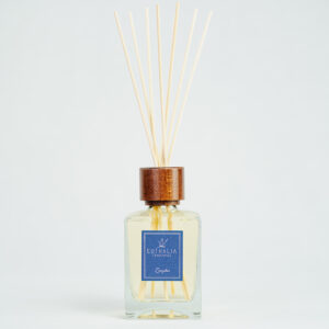 Fragranza Zanzibar. Diffusore a bastoncini Euthalia Fragrances, con flacone in vetro trasparente. Il tappo in legno e i bastoncini completano il design elegante, ideale per profumare ambienti con una fragranza raffinata e di lunga durata.