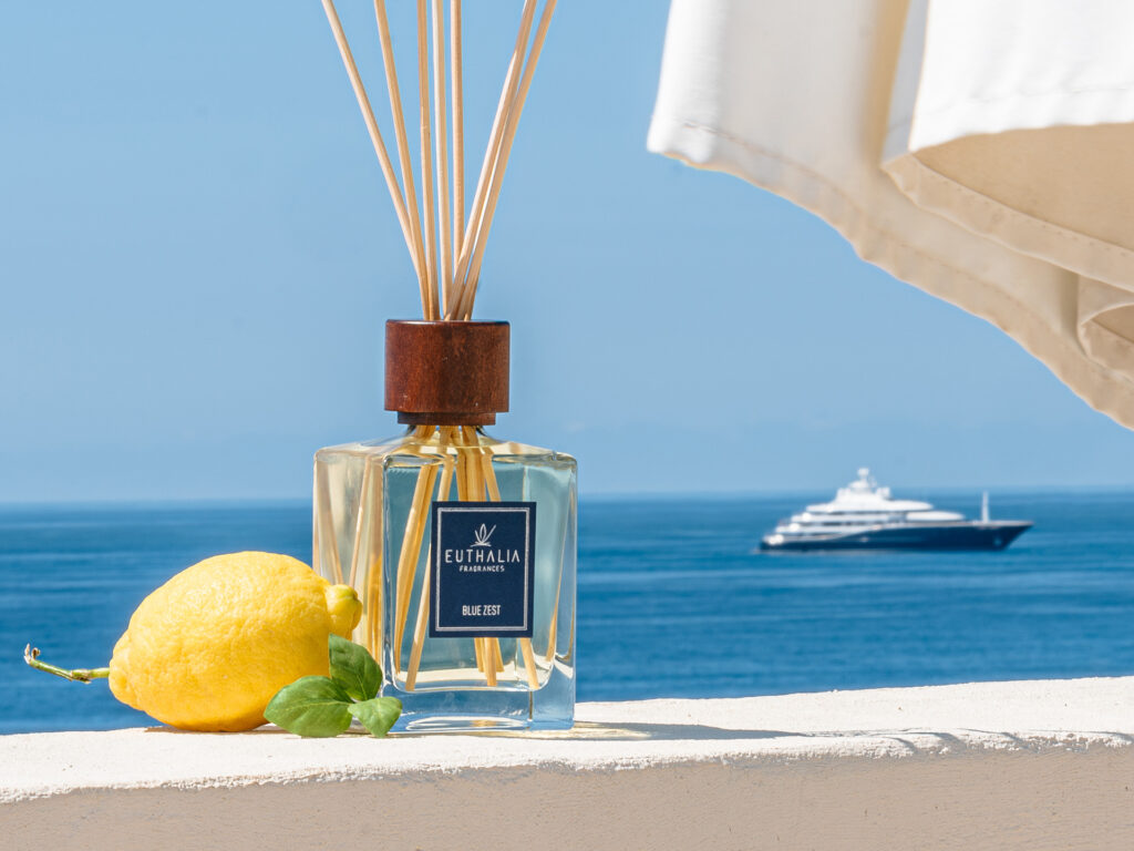 Summer time. Diffusore per ambiente Euthalia Fragrances Blue Zest con limone fresco sullo sfondo del mare, simbolo di freschezza e profumo di estate