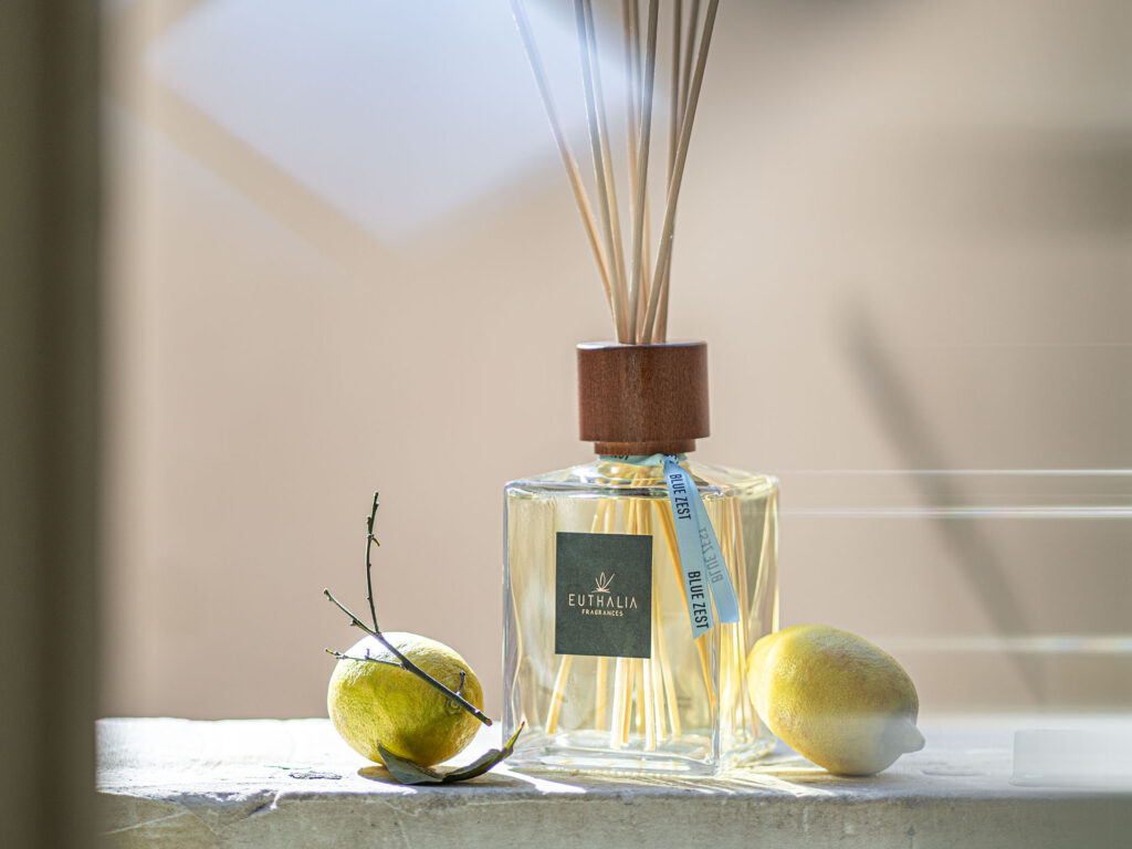 Diffusore Blue Zest Euthalia Fragrances con limoni e luce naturale, ispirato all’energia della Coppa del Mondo e alle atmosfere estive. Blue Zest reed diffuser by Euthalia Fragrances with lemons and natural light, inspired by the energy of the World Cup and summer atmospheres.