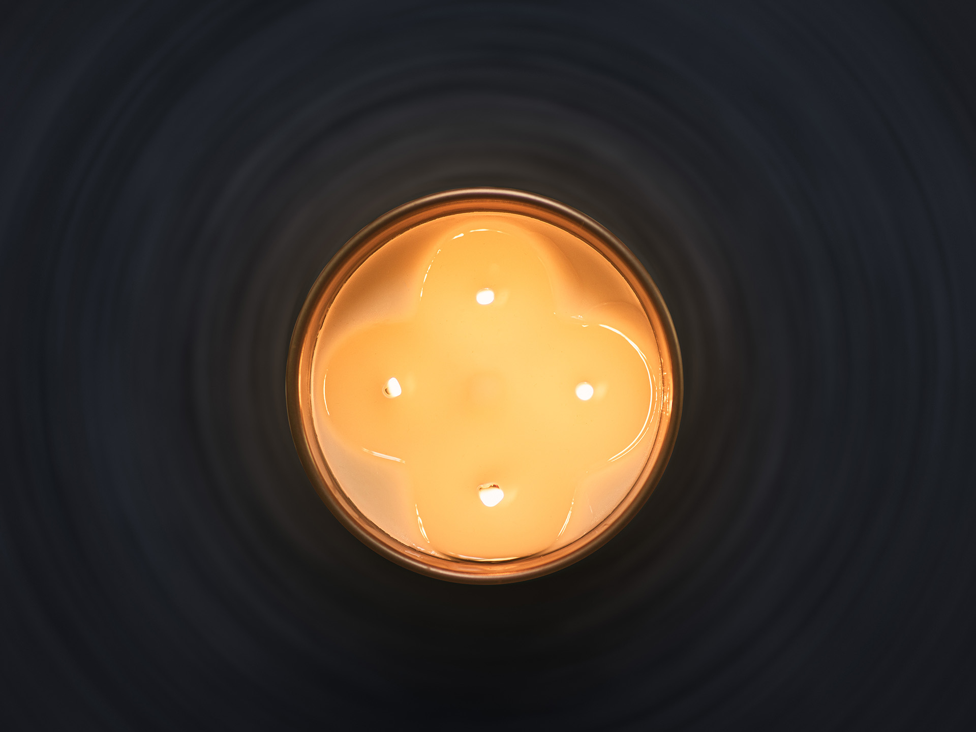 Candela profumata Euthalia Fragrances accesa, dettaglio della cura della candela per una combustione corretta e un’atmosfera elegante in casa. Euthalia Fragrances scented candle lit, a detail of candle care for proper burning and an elegant atmosphere at home.