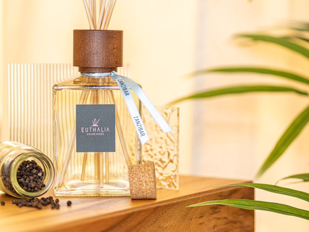 Diffusore Zanzibar Euthalia Fragrances con pepe nero e dettagli esotici, racconto visivo della piramide olfattiva della fragranza. Zanzibar reed diffuser by Euthalia Fragrances with black pepper and exotic details, a visual expression of the fragrance’s olfactory pyramid.