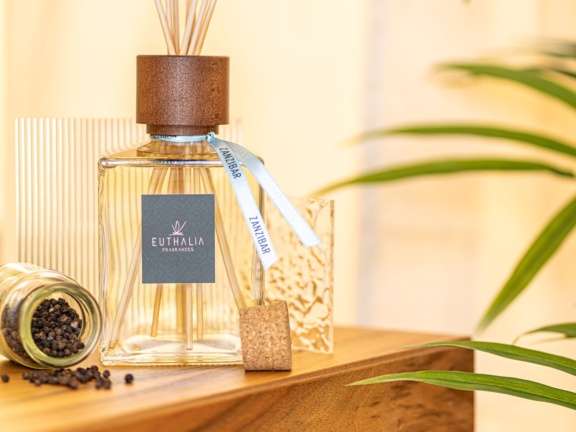 Diffusore Zanzibar Euthalia Fragrances con pepe nero e dettagli esotici, racconto visivo della piramide olfattiva della fragranza. Zanzibar reed diffuser by Euthalia Fragrances with black pepper and exotic details, a visual expression of the fragrance’s olfactory pyramid.