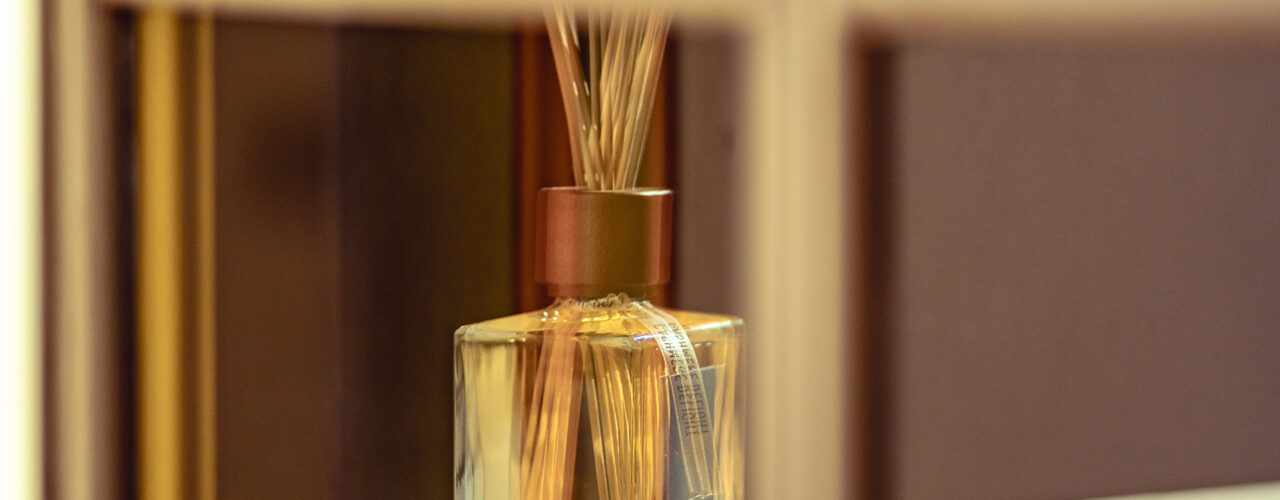 Segni zodiacali e profumi: diffusore per ambiente Euthalia Fragrances con bastoncini in un elegante interno. Zodiac signs and fragrances: Euthalia Fragrances reed diffuser in an elegant interior.