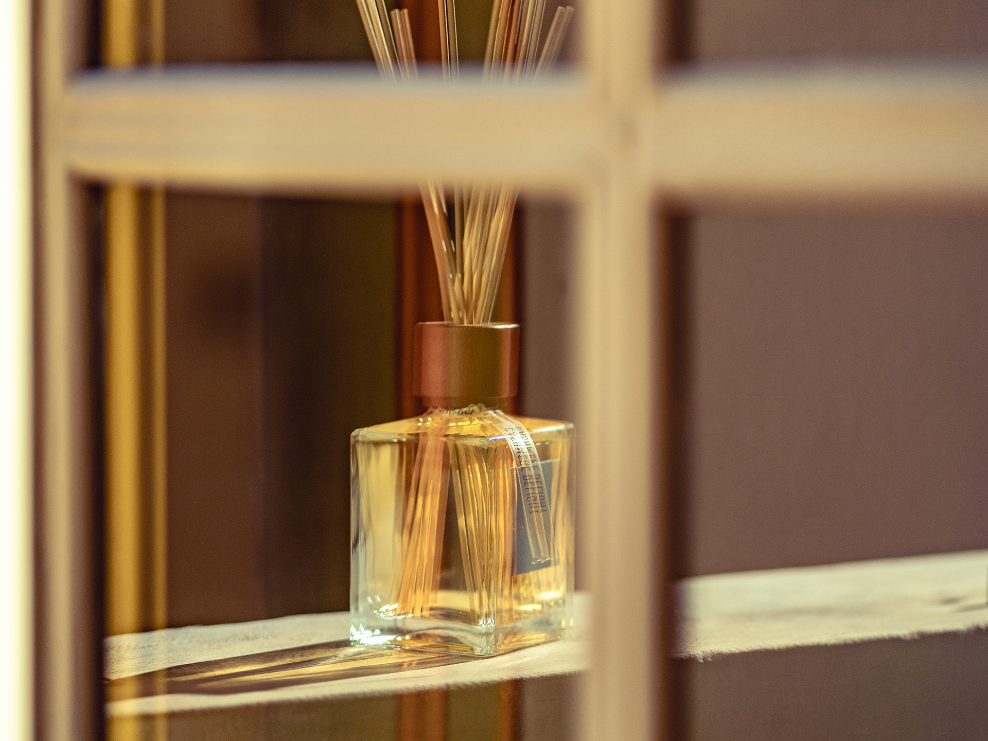 Segni zodiacali e profumi: diffusore per ambiente Euthalia Fragrances con bastoncini in un elegante interno. Zodiac signs and fragrances: Euthalia Fragrances reed diffuser in an elegant interior.
